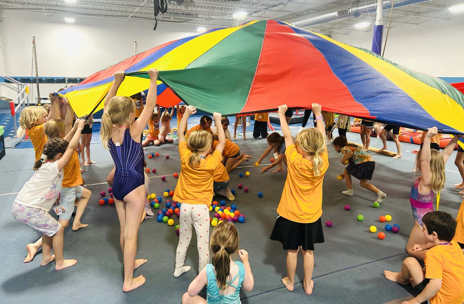 Campers play a giant parachute game together at summer day camp